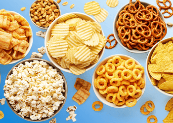 Various snacks in bowls blue background