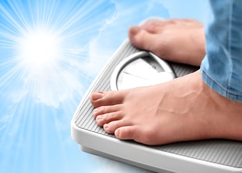 Feet measuring their weight on a scale in blue background