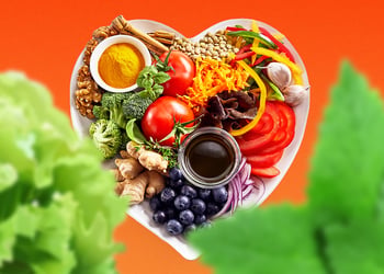 mix of vegetables, fruits, grain, nuts, herbs in a heart shape
