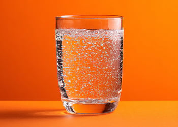 Sparkling Water in a glass orange background