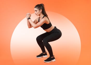 Person doing squats orange background