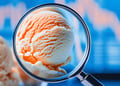 Ice cream under a magnifying glass with a blurred graph in the background