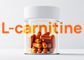 Orange L-carnitine pills in a glass container on a table grey white background