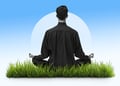 Person sitting on grass meditating back turned, blue background