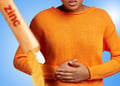 Zinc supplements spilling from a packet, person holding onto their stomach in the background