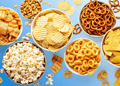 Various snacks in bowls blue background
